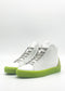 Introducing the MH0122 White & Fluorescent Yellow high-top sneakers: handcrafted in Portugal, these shoes feature gray laces and vibrant fluorescent yellow soles. Set against a plain background, they seamlessly blend style and quality.