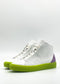 The MH0115 White & Lilac high-top sneakers feature bright green soles and a purple accent on the heel, handcrafted in Portugal from premium Italian leathers, set against a plain background.