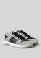 A pair of M0006 by Miteran in black, white, and gray low-top sneakers handcrafted in Portugal with white soles and black laces on a neutral background.