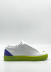 Introducing the ML0116 White & Fluorescent Yellow sneaker, meticulously handcrafted in Portugal, featuring premium Italian leathers. This stylish shoe boasts a striking green sole and a vibrant purple heel accent, beautifully displayed against a plain white background.