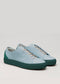 V44 Artic blue sneakers with forest green soles and elastic laces, handcrafted in Portugal. These stylish kicks feature a durable rubber cupsole, showcased elegantly on a plain background.