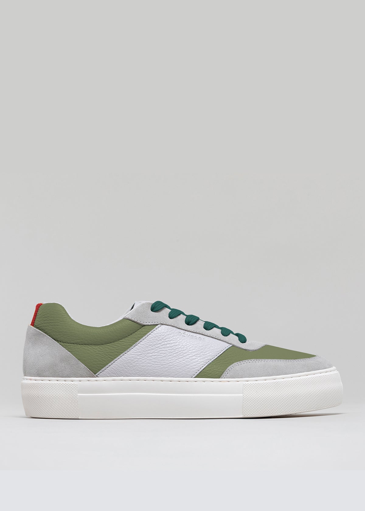 The V28 Pine & Grey showcases a side view of a low-top sneaker in green, white, and gray, with a white sole and a red accent on the heel. Handcrafted in Portugal using premium Italian leathers, this shoe perfectly blends style with quality craftsmanship.