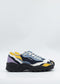 The LC0006 Multicolour sneakers, handcrafted in Portugal, showcase a thick black sole and a vibrant wavy design incorporating blue, yellow, purple, and white shades. Constructed with premium Italian leathers, these shoes are ethically made to order, ensuring a unique blend of style and sustainability.