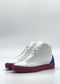 The MH0141 White & Red high-top sneakers are meticulously handcrafted from premium leather, featuring striking red soles and blue accents on the back, set against a plain background.