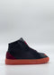 The MH0145 Black & Scarlet sneaker is a black high-top crafted from premium Italian leather, featuring a vibrant orange sole. When viewed from the side against a plain white background, this ethically made product merges style with conscious craftsmanship.