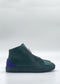 The MH0147 Emerald Green & Purple high-top sneakers, crafted from premium Italian leathers with purple accents, are viewed from the side against a plain white background.