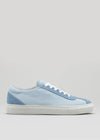 The V8 Sky & Jeans sneaker, a light blue low-top handcrafted in Portugal, showcases premium canvas with white laces and a white sole, displayed in a side view against a gray background.