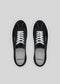 Top view of a pair of V7 Black premium canvas sneakers, showcasing white laces and soles, set against a gray background.