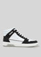 The V3 Black W/ White is a high-top sneaker expertly handcrafted in Portugal, showcasing premium Italian leathers in an elegant black and white design. This fashionable shoe features crisp white laces and a sleek white sole, all complemented by a subtle gray background.