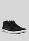 The V5 Black, a pair of handcrafted high-top sneakers made in Portugal from premium Italian leathers, sits elegantly against a light gray background, showcasing its stylish design with contrasting white soles.