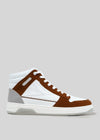 Introducing the V6 Caramel W/ White, a retro-future high-top sneaker with a striking white and brown upper, complemented by a gray heel and pristine white sole, set against a plain gray background. These sneakers are handcrafted in Portugal using premium Italian leathers, offering a perfect blend of timeless style and innovative design.