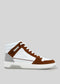 Introducing the V6 Caramel W/ White, a retro-future high-top sneaker with a striking white and brown upper, complemented by a gray heel and pristine white sole, set against a plain gray background. These sneakers are handcrafted in Portugal using premium Italian leathers, offering a perfect blend of timeless style and innovative design.