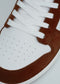 Close-up of the V6 Caramel W/ White sneaker, showcasing a retro-future design with white premium Italian leathers, brown suede detailing, and white laces, handcrafted in Portugal.