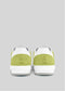 A pair of handcrafted V10 Brat sneakers in green and white viewed from the back against a plain gray background.