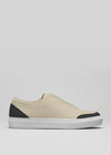 The V20 Beige Floater W/ Black is a sleek low-top sneaker featuring a beige and black color scheme, complemented by a white sole. It boasts a minimalist design crafted from premium Italian leathers, all showcased against a plain gray background. Handcrafted in Portugal, each pair is ethically made to order for those with discerning tastes.