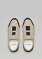 A pair of V20 Beige Floater W/ Black slip-on shoes featuring white soles on a gray background, crafted from premium Italian leathers. The "D:VERGE" logo is visible inside the shoes, highlighting their ethically made-to-order design.