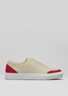 The V19 Beige w/ Scarlet is a handcrafted sneaker made in Portugal, showcasing red accents on the heel and toe with a white rubber sole, crafted from premium Italian leathers against a plain background.