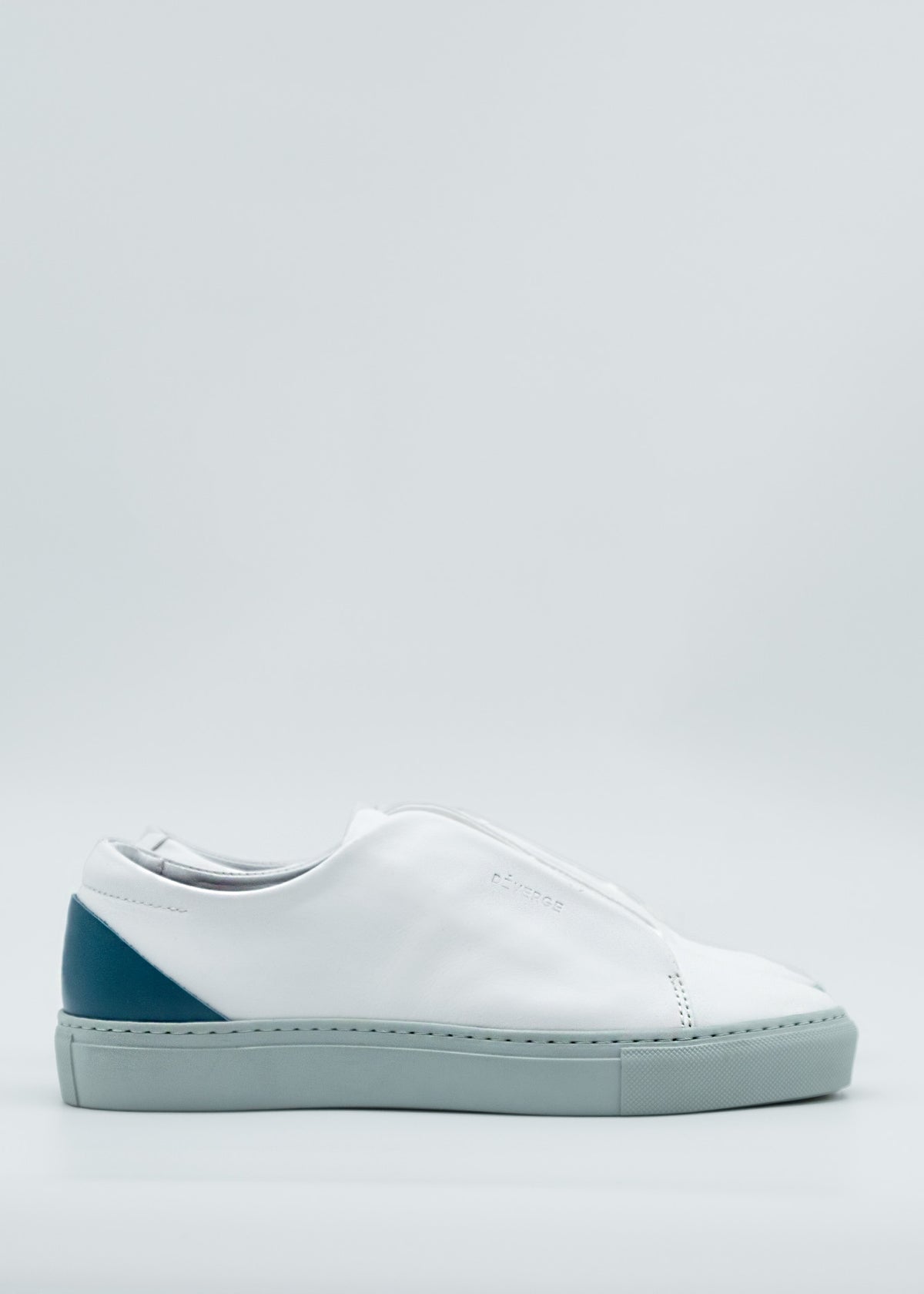 Introducing the ML0096 White & Green, a handcrafted sneaker featuring a white design with a gray sole and an eye-catching blue heel accent. Made from premium Italian leathers and ethically crafted to order in Portugal, this shoe is artfully showcased from the side against a light background.