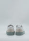 A pair of ML0104 Pastel Green & White handcrafted sneakers made from premium Italian leathers, featuring light gray soles, viewed from the back against a plain background.