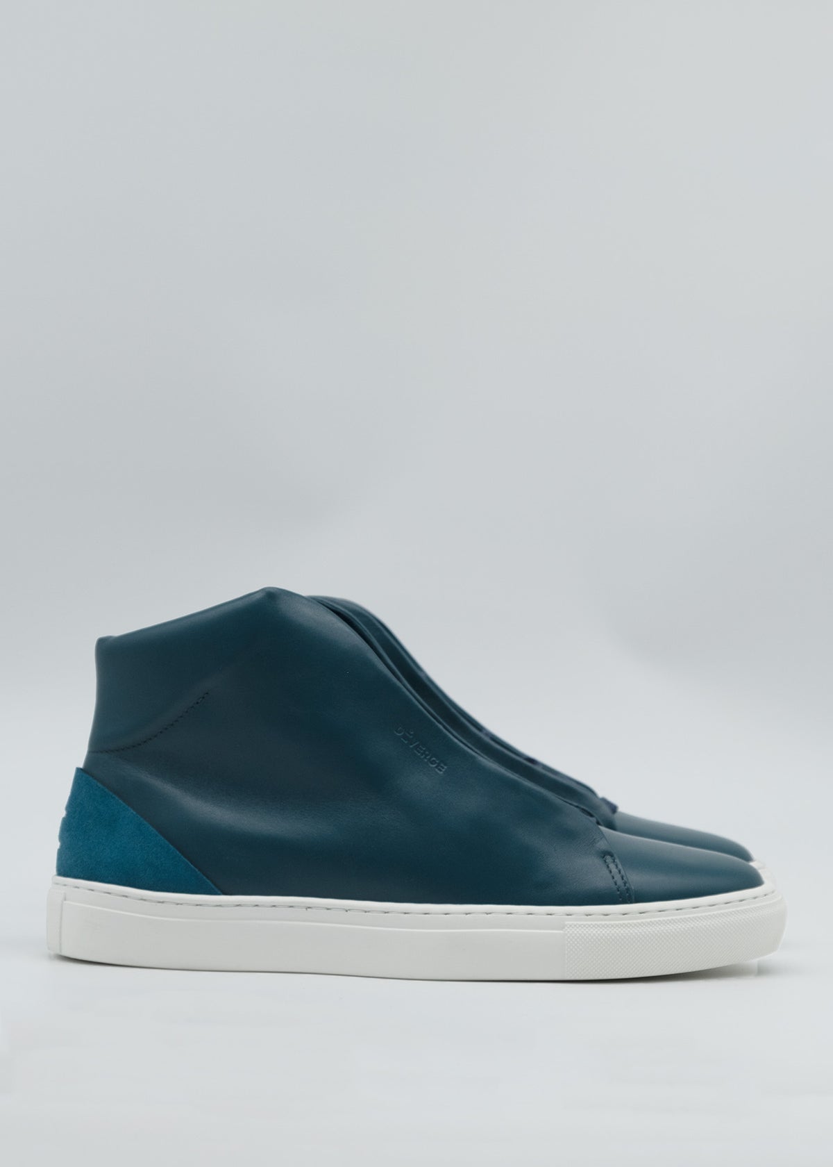 The MH0132 Ocean Blue high-top sneakers feature dark teal leather with white soles and a teal suede accent at the heel, skillfully handcrafted in Portugal from premium Italian leathers, showcased against a light gray background.