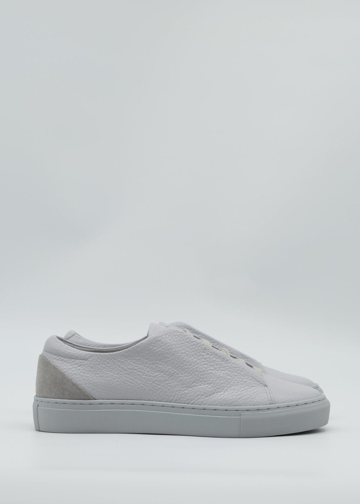 Side view of the ML0100 Grey Floater sneakers showcasing premium Italian leathers and a gray suede accent on the heel, set against a light gray background.