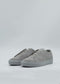 ML0101 Grey Suede sneakers feature gray suede uppers with white soles, crafted from premium Italian leathers and displayed on a neutral background. These shoes are handcrafted in Portugal for timeless style and quality.