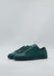 A pair of Emerald Green Floater ML0102 sneakers, crafted from premium Italian leathers, laced up and viewed from the side against a light gray background. Ethically made to order, these shoes blend style with conscious craftsmanship.