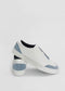 A pair of SO0028 White W/ Blue slip-on sneakers with light blue accents on the toe and heel, handcrafted in Portugal, displayed against a white background. One shoe rests on the other, showcasing the side and back views.