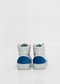 A pair of MH0106 Grey W/ Blue high-top sneakers with blue accents on the heels, viewed from the back, against a white background. Handcrafted in Portugal from premium Italian leathers, these sneakers are ethically made to order.