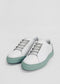 A pair of ML0078 White W/ Pastel Green sneakers with light green soles and grey laces on a plain white background, ethically made to order and handcrafted in Portugal.