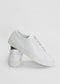 A pair of ML0065 White Leather sneakers, handcrafted in Portugal from premium Italian leathers, with one shoe standing upright and the other placed diagonally against it, on a plain white background.