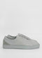 A pair of ML0072 Grey Floater W/ Plaster, handcrafted in Portugal using premium Italian leathers, is shown against a plain white background. The shoes feature a simple, clean design with white rubber soles and laces, with no visible branding. Ethically made to order.