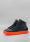 A pair of MH0121 Grey Floater high-top sneakers with bright orange soles, expertly handcrafted in Portugal, placed against a neutral grey background.