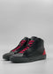 A pair of MH0124 Black Leather W/ Red high-top sneakers, featuring handcrafted black Italian leather with red panels on the back and vibrant red laces, set against a plain gray background.