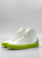 The MH0125 White Leather W/ Pastel Green high-top sneakers, featuring a bright green sole and light blue heel accents, handcrafted in Portugal, are displayed against a plain grey background.