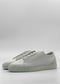 A pair of ML0095 Grey Floater W/ Plaster low-top sneakers, handcrafted in Portugal from premium Italian leathers, set against a plain gray background.