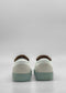 A pair of SO0031 White Leather W/ Green sneakers is shown from the back against a plain gray background, featuring white uppers with light green soles. These handcrafted sneakers are ethically made to order in Portugal using premium Italian leathers.