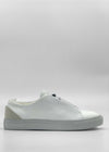 A side view of the ML0091 White Vegan W/ Grey sneaker, featuring a white sole and light beige detail on the heel, handcrafted in Portugal from premium Italian vegan leathers. The minimalist design showcases a clean look with no visible laces. The background is plain white.