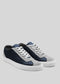 Introducing the V12 Dark Blue w/ Plaster: a pair of casual low-top sneakers crafted with gray and blue premium Italian leather panels, complemented by white laces and durable white rubber soles, set against a plain background.