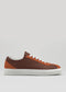 Introducing the V7 Brown & Caramel: a handcrafted low-top sneaker made in Portugal with premium Italian leathers, featuring a rich brown and orange palette. It comes with white laces and a white sole, all set against a plain gray background.