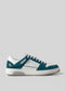 A stylish V9 Petrol Blue w/White sneaker, handcrafted in Portugal from premium Italian leathers, featuring perforated details, contrasting green accents, and a white rubber sole. Perfectly viewed from the side against a plain grey background.