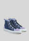 The TH0019 by Linda is a pair of high-top sneakers, handcrafted in Portugal, featuring a mix of navy blue and lavender suede panels, white rubber soles, white eyelets, and black laces.