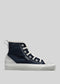 TH0017 by Khadija is a high-top sneaker with a navy blue premium canvas upper, white laces, and a gray suede heel and toe cap, featuring a pull tab at the back. Handcrafted in Portugal, this ethically made shoe combines style and quality.