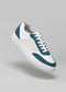 A low-top, lace-up V28 White & Petrol Blue sneaker made from premium Italian leathers with white, green, and gray panels is shown against a plain gray background.